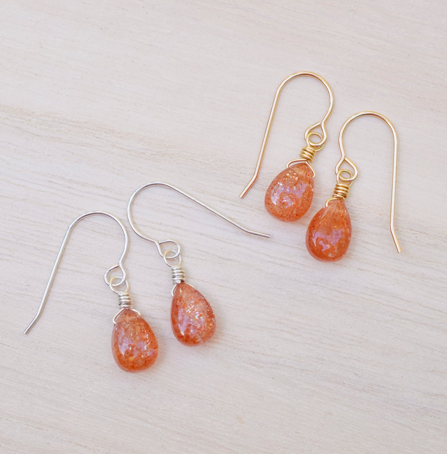 Genuine orange sunstone teardrop dangle earrings shown in 14k gold filled and sterling silver. The gemstones are smooth polished.