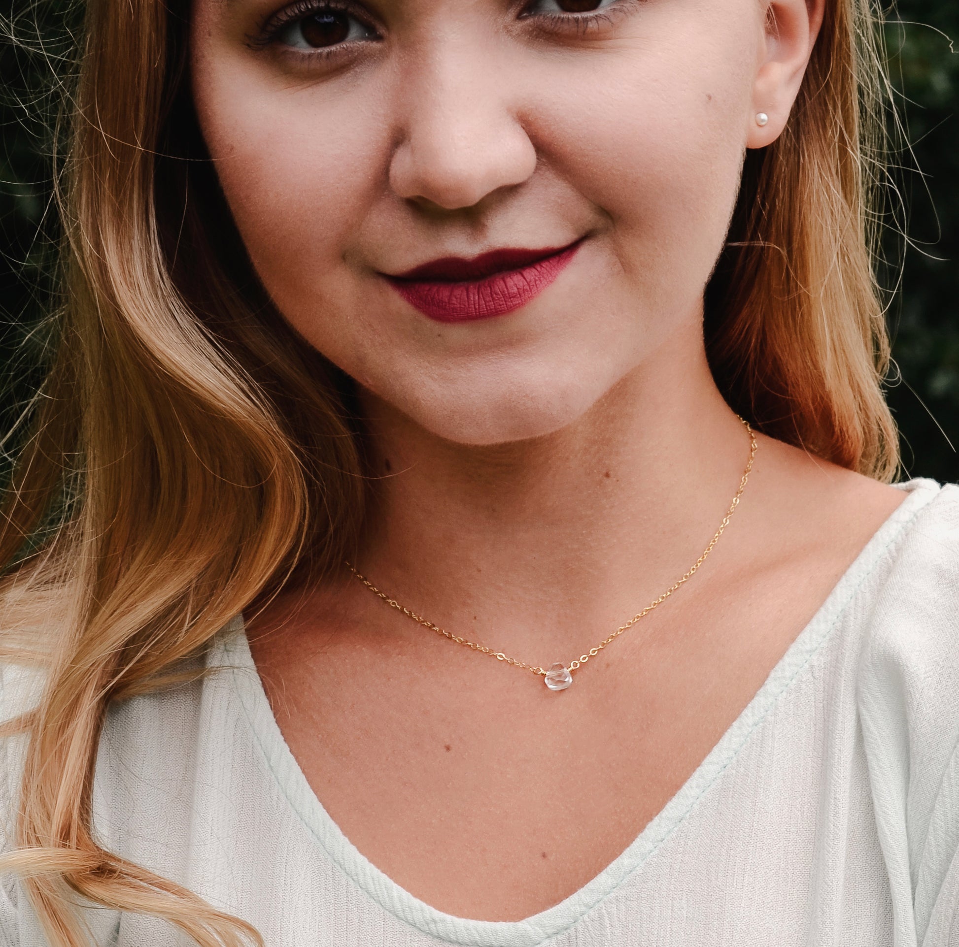 A clear, natural crystal quartz faceted teardrop set onto a 14k gold filled chain. Modeled image.