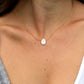 modeled image. A dainty flat, oval-shaped white freshwater pearl is set within a 14k gold filled or sterling silver chain. Both styles are shown.
