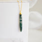 Long green, white, and clear real natural moss agate stone set on a 14k gold filled chain. The pendant is a long thin oval shape.