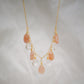 Orange, peach moonstone and clear Crystal Quartz teardrops dangle off a 14k gold filled chain. 