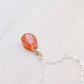 Orange Sunstone smooth polished teardrop pendant on a sterling silver chain.