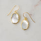 A pair of natural oval mother of pearl earrings dipped in 24k gold and set on 14k gold filled earwires. The shells are smooth polished and flash shades of white and silver.