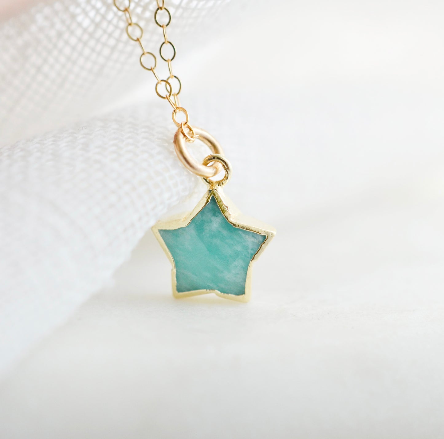 Dainty, natural aqua amazonite celestial stone star pendant set on a 14k gold filled chain. This image is a close up of the gemstone's natural aqua-blue color. This necklace is a great gift for night sky lovers, girlfriends, mom, wife, or daughter.