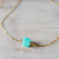 Genuine aqua blue Amazonite gemstone cut into a faceted cube and suspended on a gold filled cable chain. Close Up.