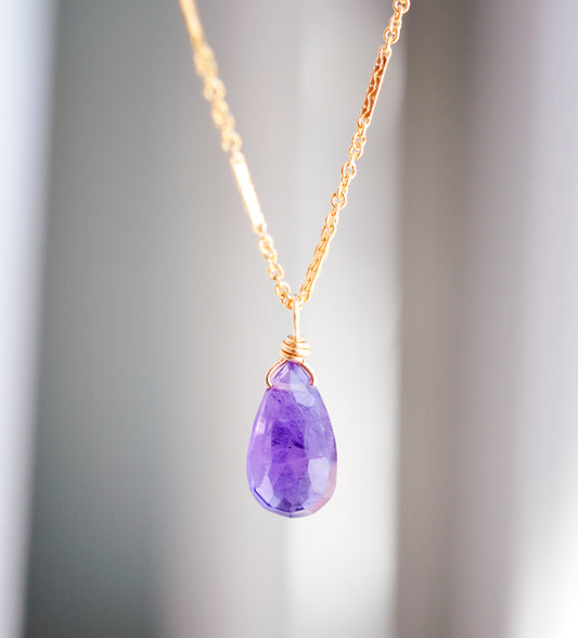 Close up of natural purple Amethyst teardrop pendant set onto a gold filled "glimmer" chain.