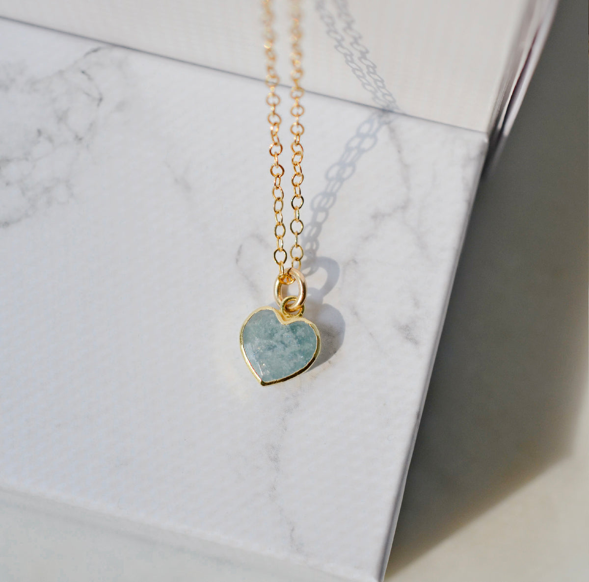 Pale blue natural aquamarine gemstone heart pendant set on a 14k gold filled chain. The stone is genuine and faceted with a 18k gold electroplate bezel.