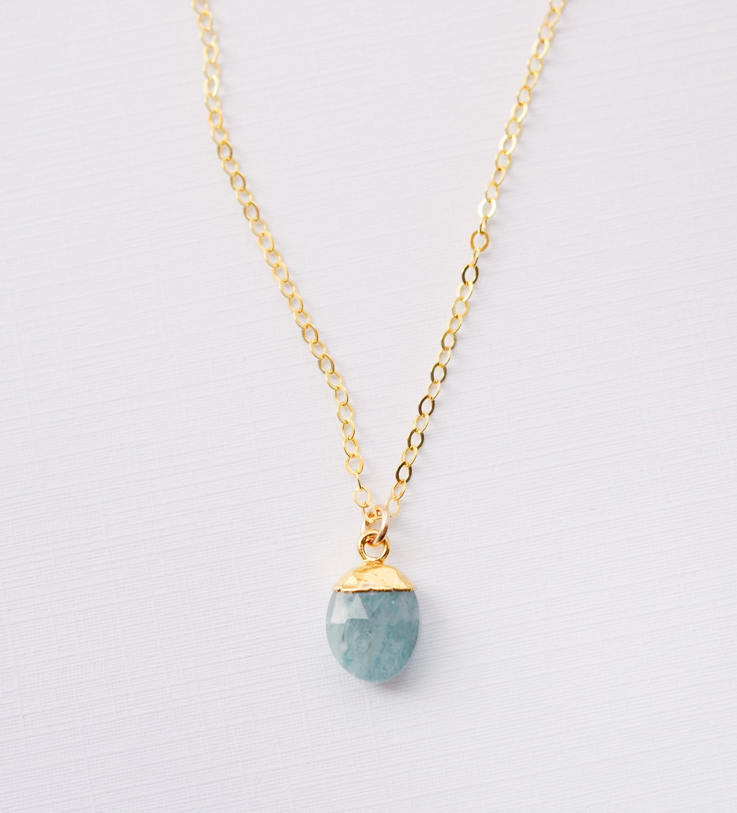 Dainty minimalist gemstone necklace with a blue faceted aquamarine teardrop pendant on a 14k gold filled chain.