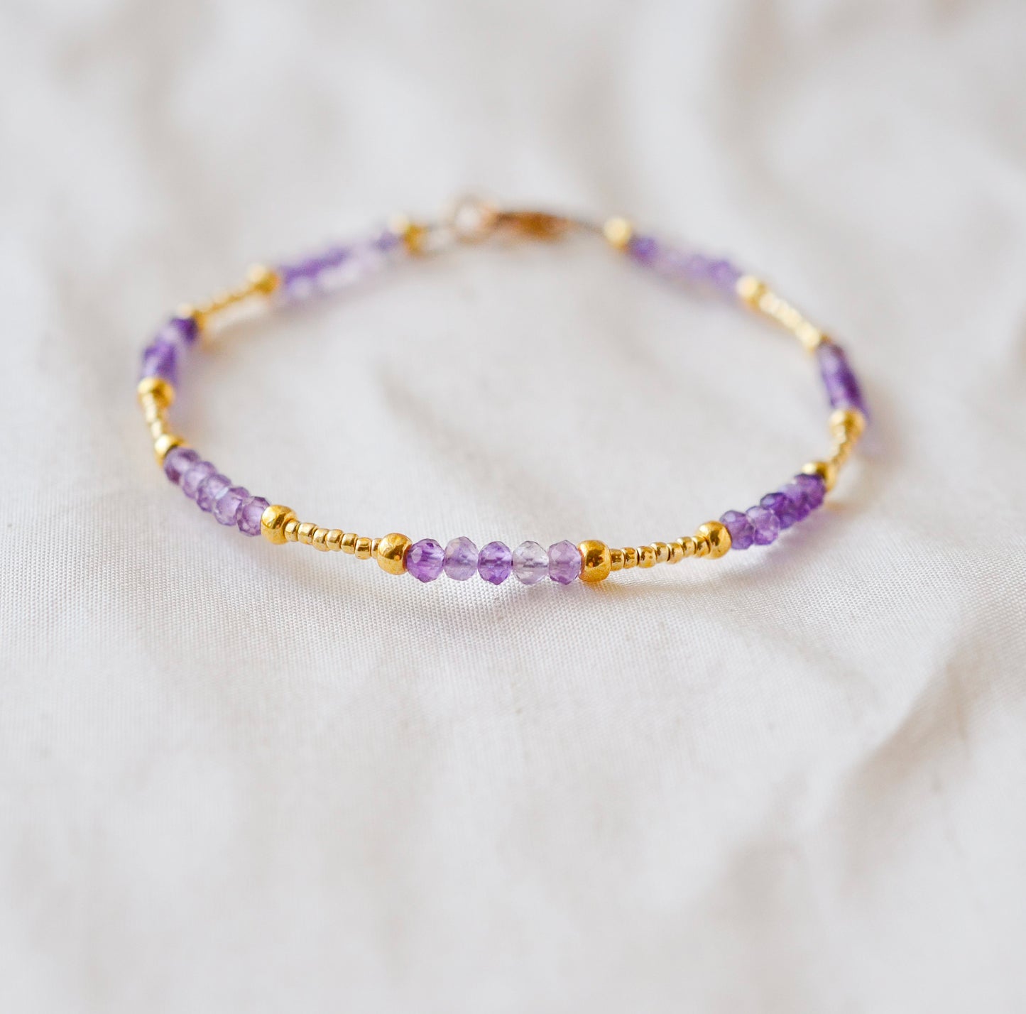 Handmade beaded gemstone crystal bracelet in gold filled or sterling silver. These bracelets feature a gemstone of your choice on a bracelet that can be stacked with others or worn alone.  Shown in purple amethyst.