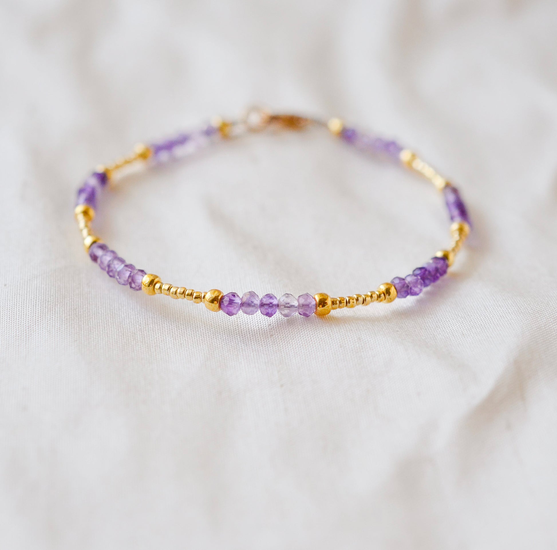 Handmade beaded gemstone crystal bracelet in gold filled or sterling silver. These bracelets feature a gemstone of your choice on a bracelet that can be stacked with others or worn alone.  Shown in purple amethyst.