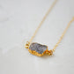 Side view of a natural black, gray druzy crystal gemstone on a 14k gold filled chain necklace.