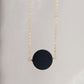 A smooth polished large black onyx coin stone set on a 14k gold filled chain. This necklace is handmade by Gemnia Jewelry in Connecticut.