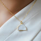 A gold-filled half moon shaped necklace with a milky white quartz druzy centerpiece.