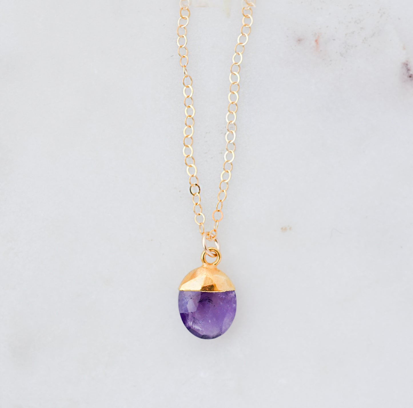 Necklace with a purple amethyst teardrop pendant and 14k gold filled dainty chain. Handmade gemstone jewelry in Connecticut by GEMNIA.