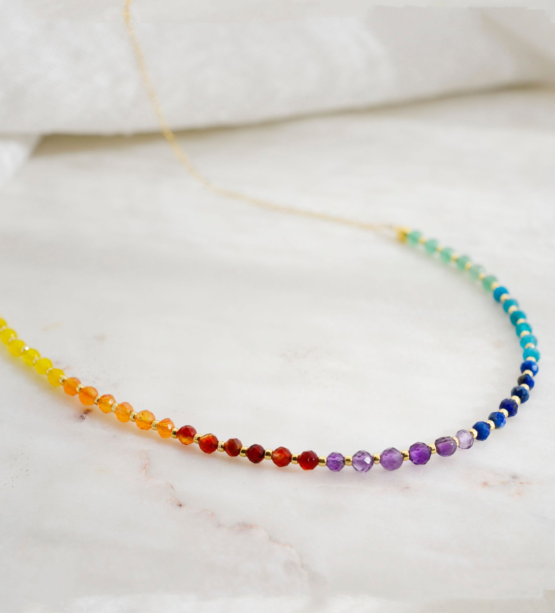 Close up of the gemstones in this beaded rainbow necklace made of natural crystal gemstones. The 14k gold filled style is shown. Handmade in New England by Gemnia.