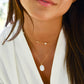 Modeled image of a woman wearing two handmade, layered necklaces of genuine white freshwater pearls and natural mother of pearl in 14k gold filled.
