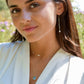 Woman wearing labradorite and pearl earrings alongside layered gemstone necklaces. All jewelry is handmade in Connecticut by Gemnia.