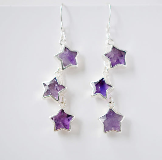 Sterling silver celestial amethyst star earring jewelry. Each earring features three purple amethyst stars dangling from a sterling silver chain.
