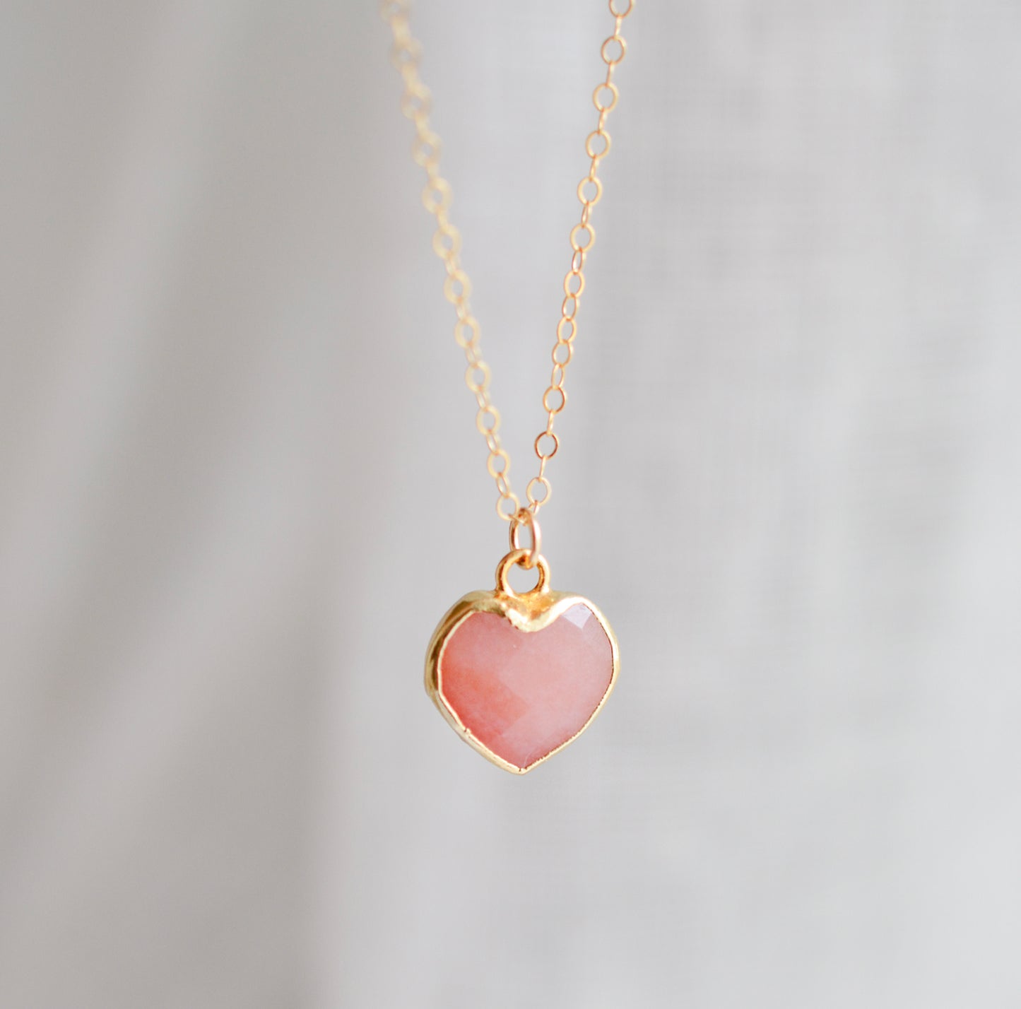 Handmade necklace with a natural pink opal heart-shaped pendant on a 14k gold filled chain. Handcrafted dainty gemstone jewelry by Gemnia.
