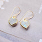 Natural rainbow moonstone stone heart earrings in gold. The stones are white, but flash blue with movement.