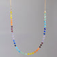 Rainbow chakra gemstone necklace. Crystals are beaded together in this pattern: yellow, orange, red, purple, blue, aqua, green. The gold style is shown.