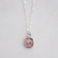 Natural pink Rhodochrosite sliced gemstone bezeled in sterling silver and set on a sterling chain.