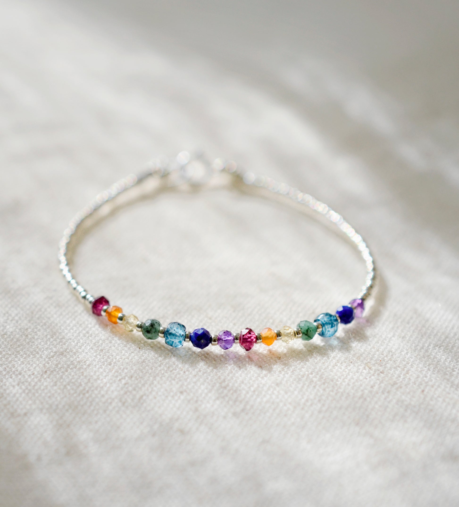 this dainty minimalist bracelet is handmade in Connecticut with natural crystal gemstones in order of the chakras. The stones are arranged like a rainbow. 