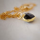 Black Onyx gold heart necklace. A black stone heart bezeled in gold is suspended from a 14k gold filled chain.