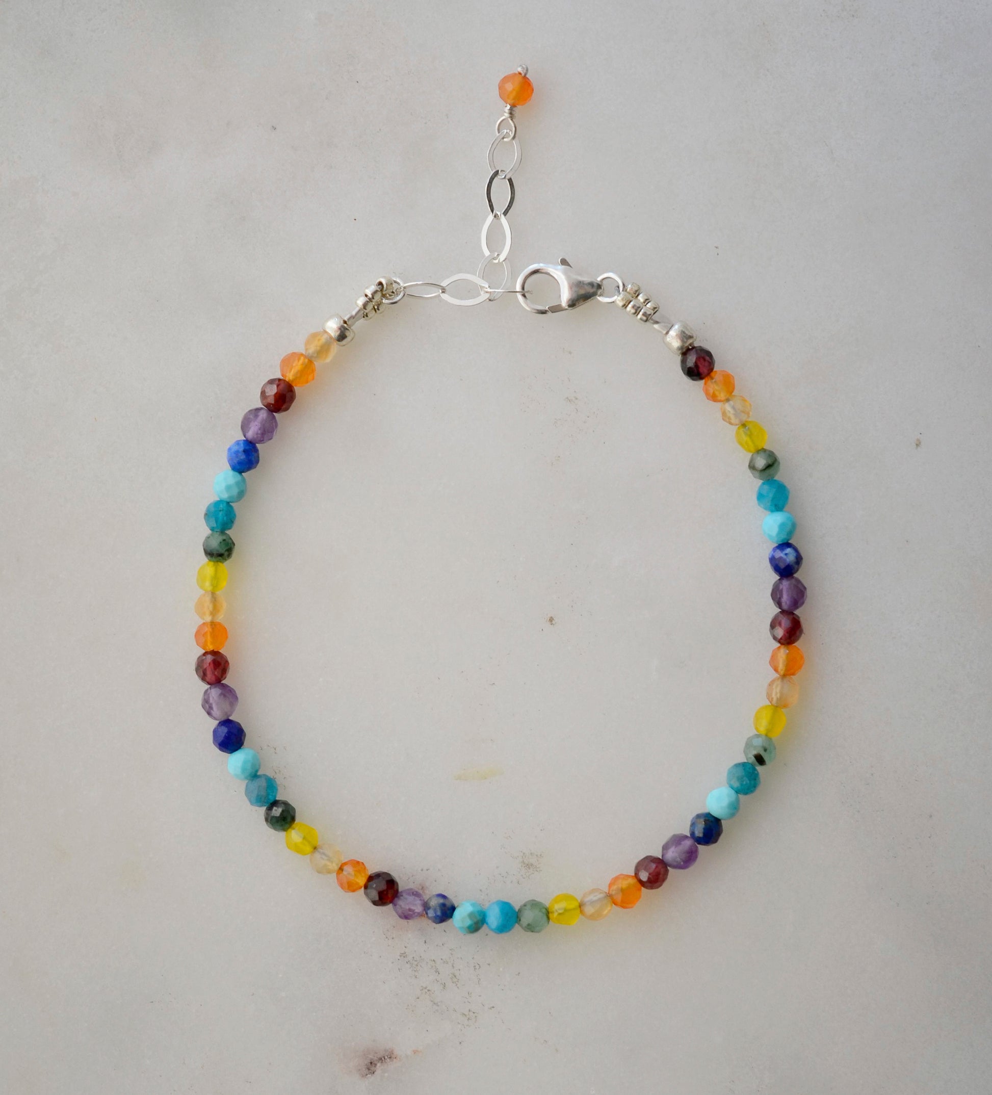 A dainty, beaded, multi-color gemstone bracelet depicting the rainbow, pride, or the chakras. Natural crystals include: turquoise, apatite, emerald, garnet, yellow opal, amethyst, aventurine, and lapis lazuli. Handcrafted in Connecticut by Gemnia Jewelry.