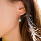 A woman wearing a dainty star earring handmade with blue turquoise and 14k gold filled. 