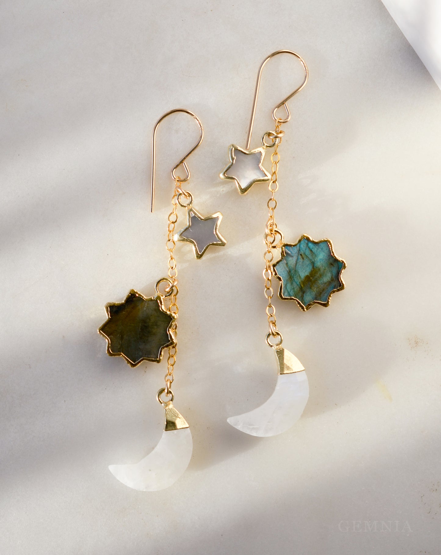 Pair of handmade earrings with star, moon, and turquoise stone designs in 14k gold filled. Handmade in Connecticut by Gemnia.