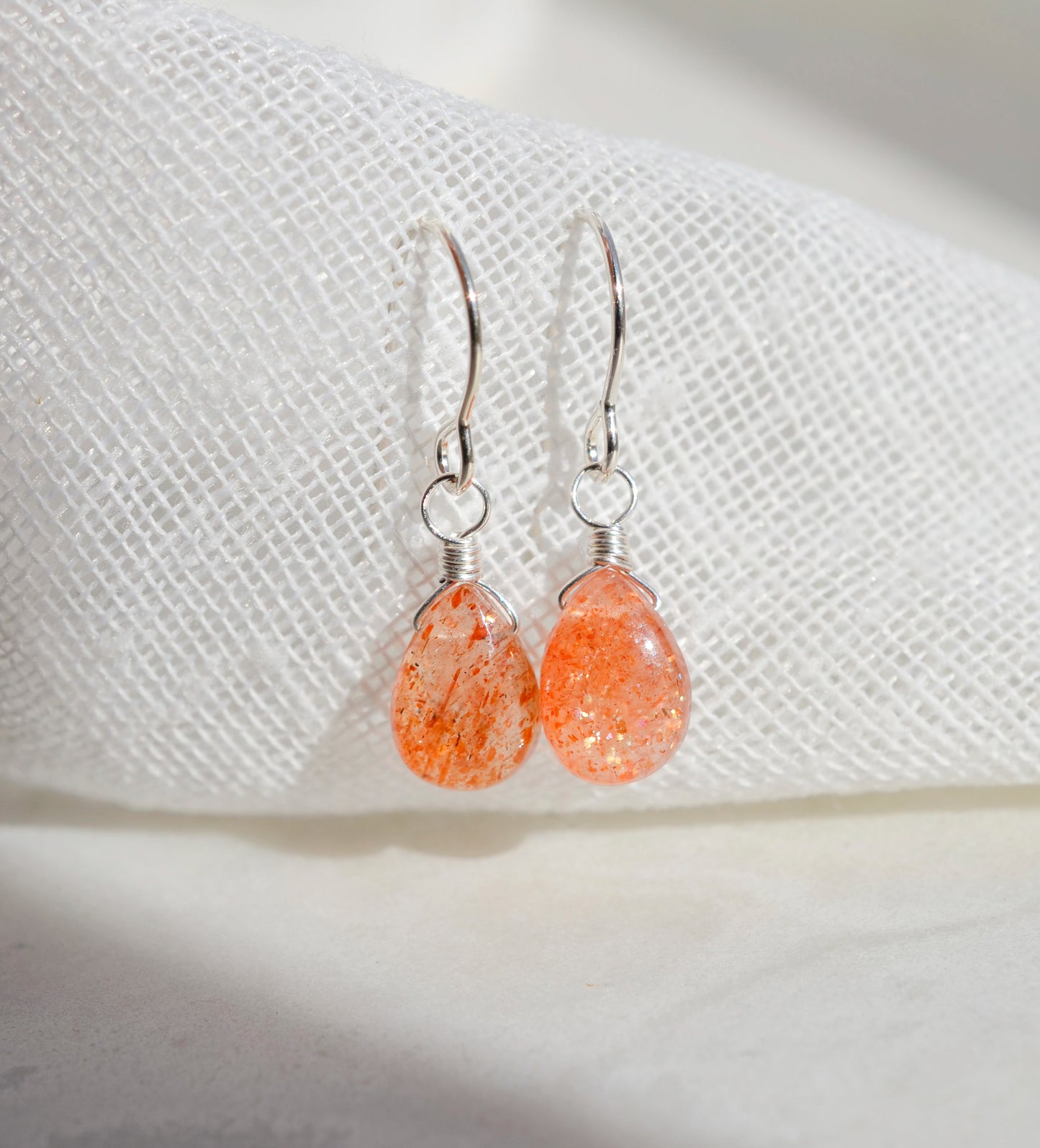 Handmade natural sunstone teardrop dangle earrings in sterling silver. These dainty, genuine stone earrings are made by Gemnia in Connecticut. 