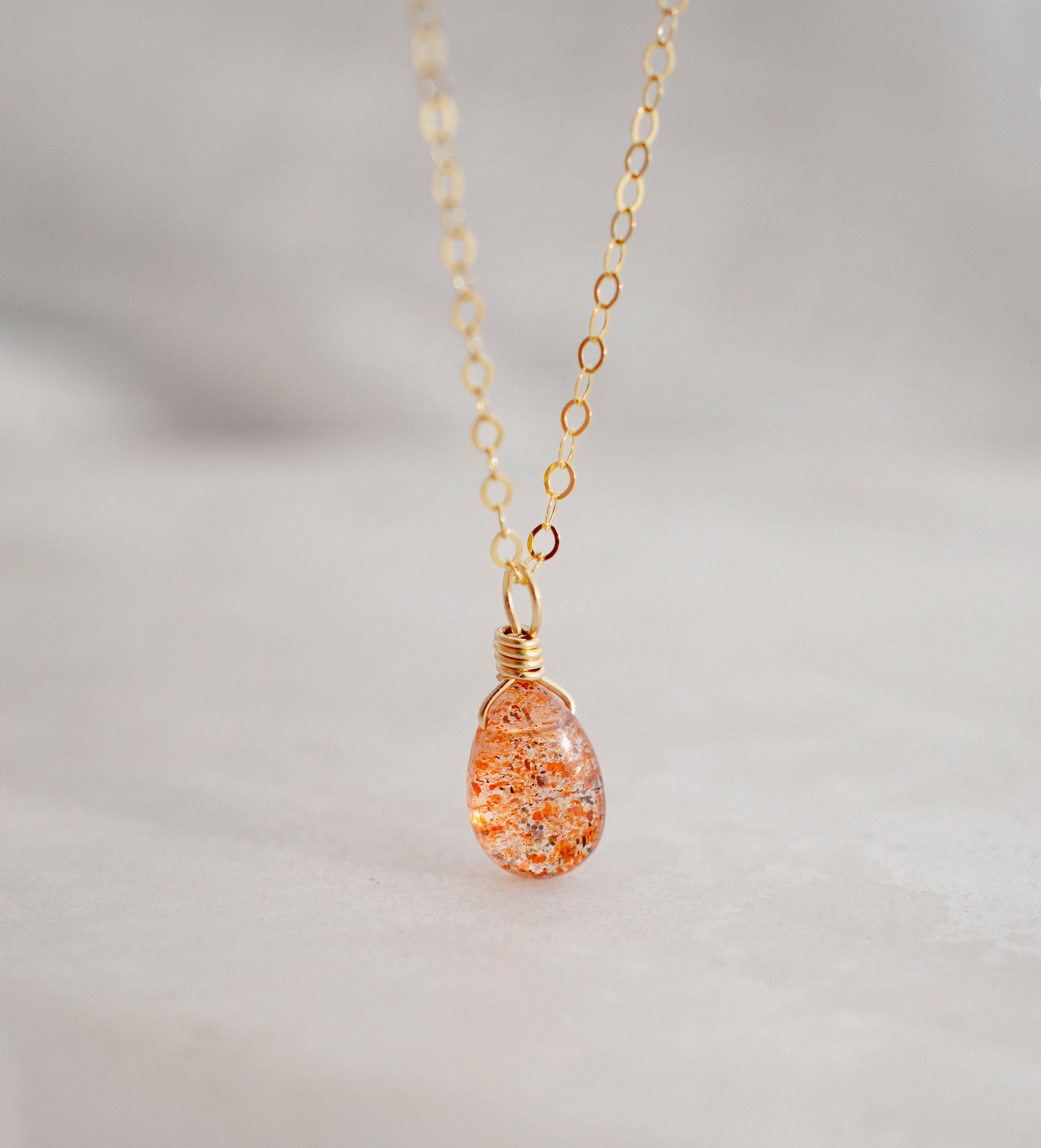 Orange Sunstone smooth polished teardrop pendant on a 14k gold filled chain. Stones shimmer in the light and when turned from side to side. 