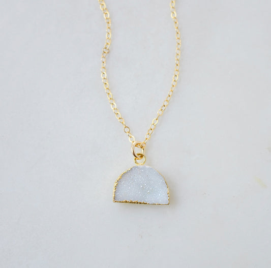 This necklace is handmade with a natural white druzy quartz pendant in a half-circle or crescent shape. Available in 14k gold filled.