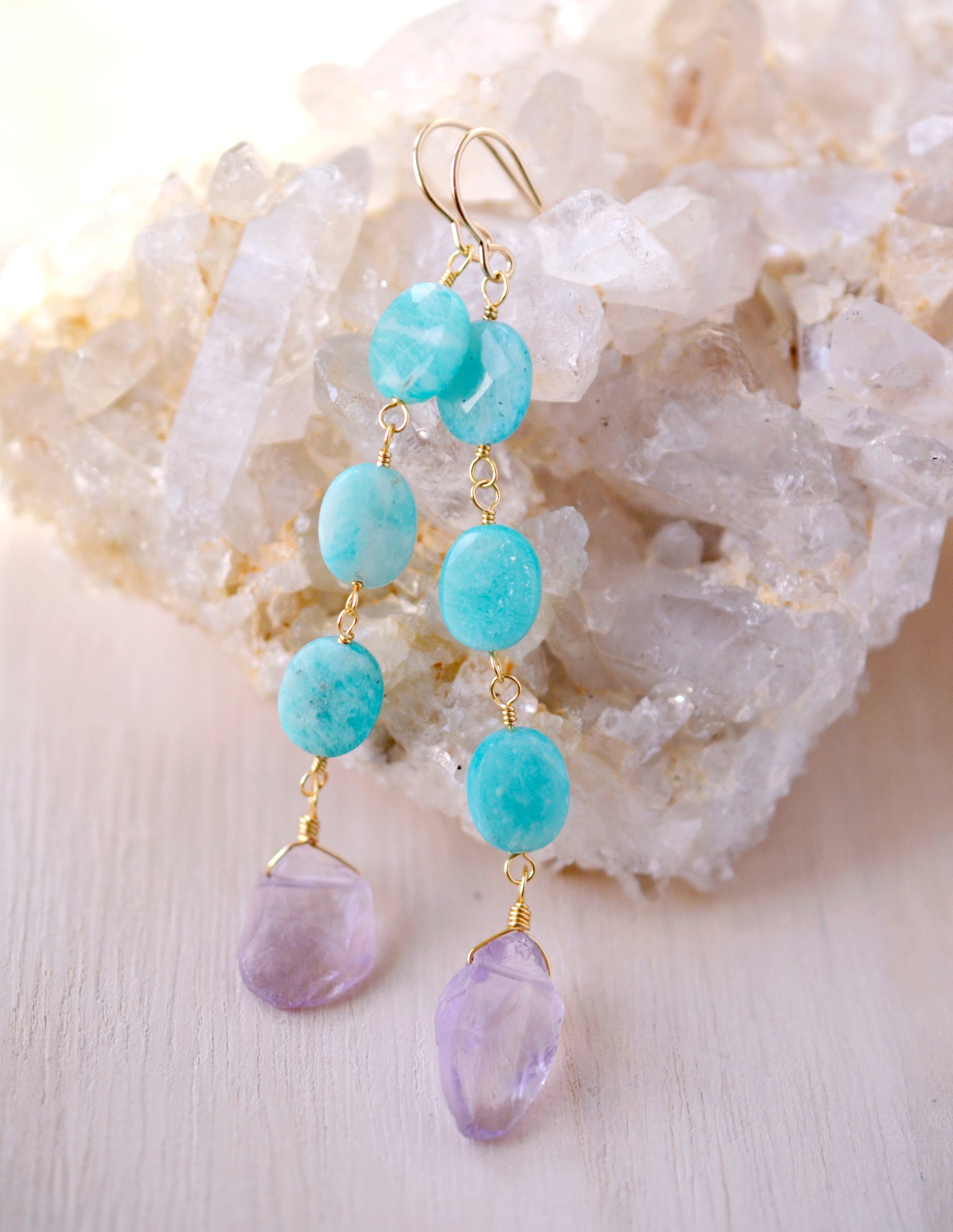 Three Amazonite faceted oval stones hang over raw, pale purple Amethyst crystals. Shown in the 14k gold filled style.