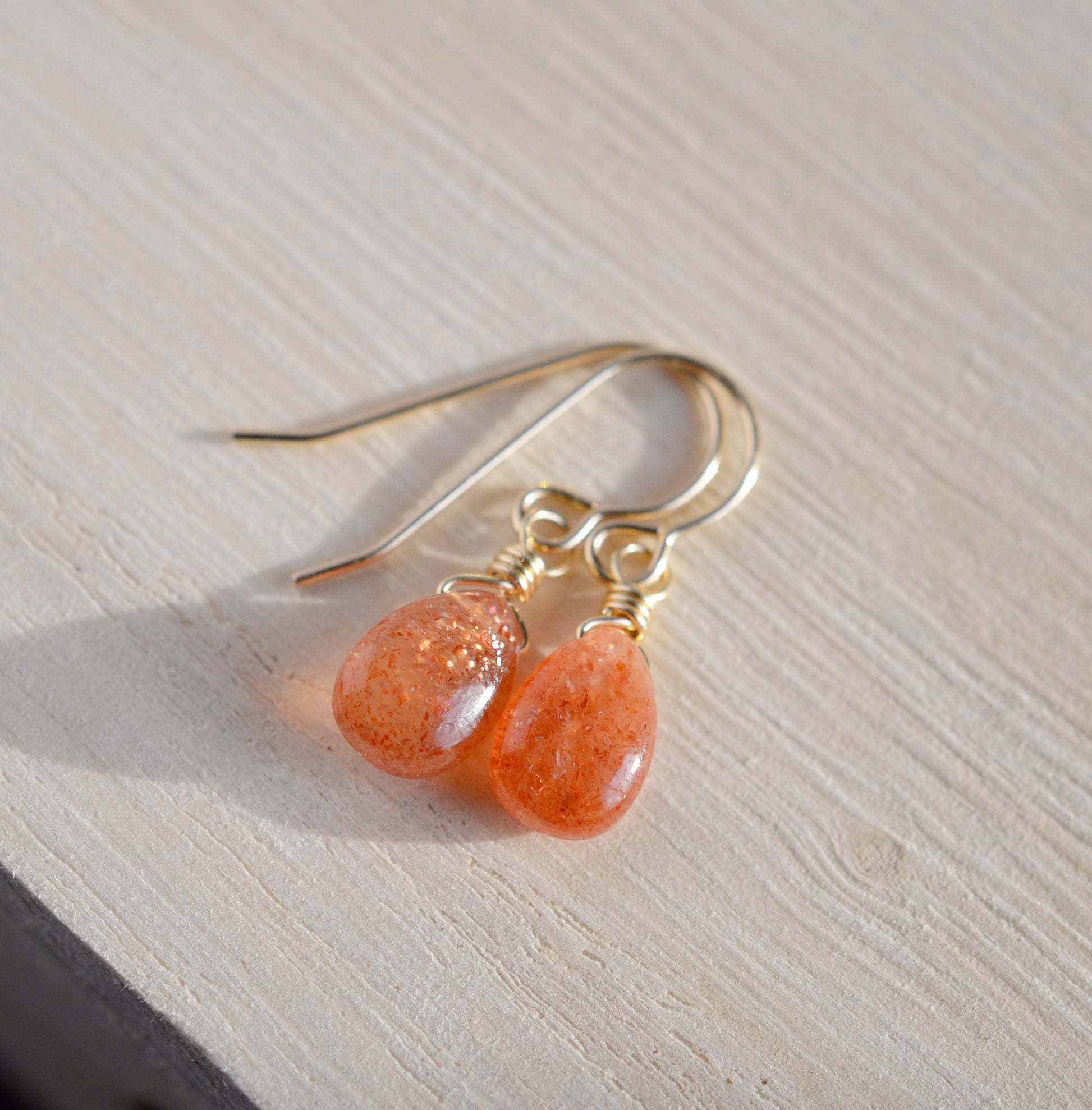 Genuine, smooth polished orange Sunstone teardrops suspended from 14k gold filled earwires.