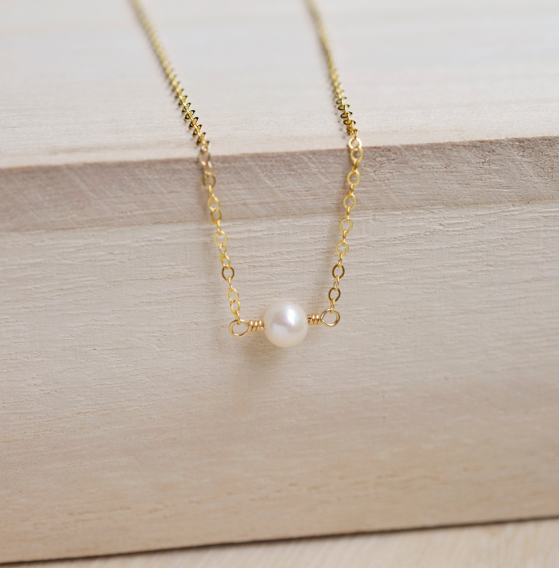 Single round white freshwater pearl necklace on a 14k gold filled chain.
